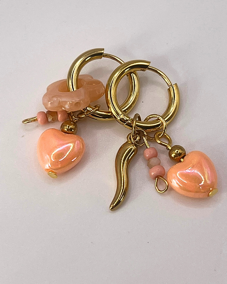 Goudkleurige sweetheart oorringen met zalmkleurige hartjesbedels