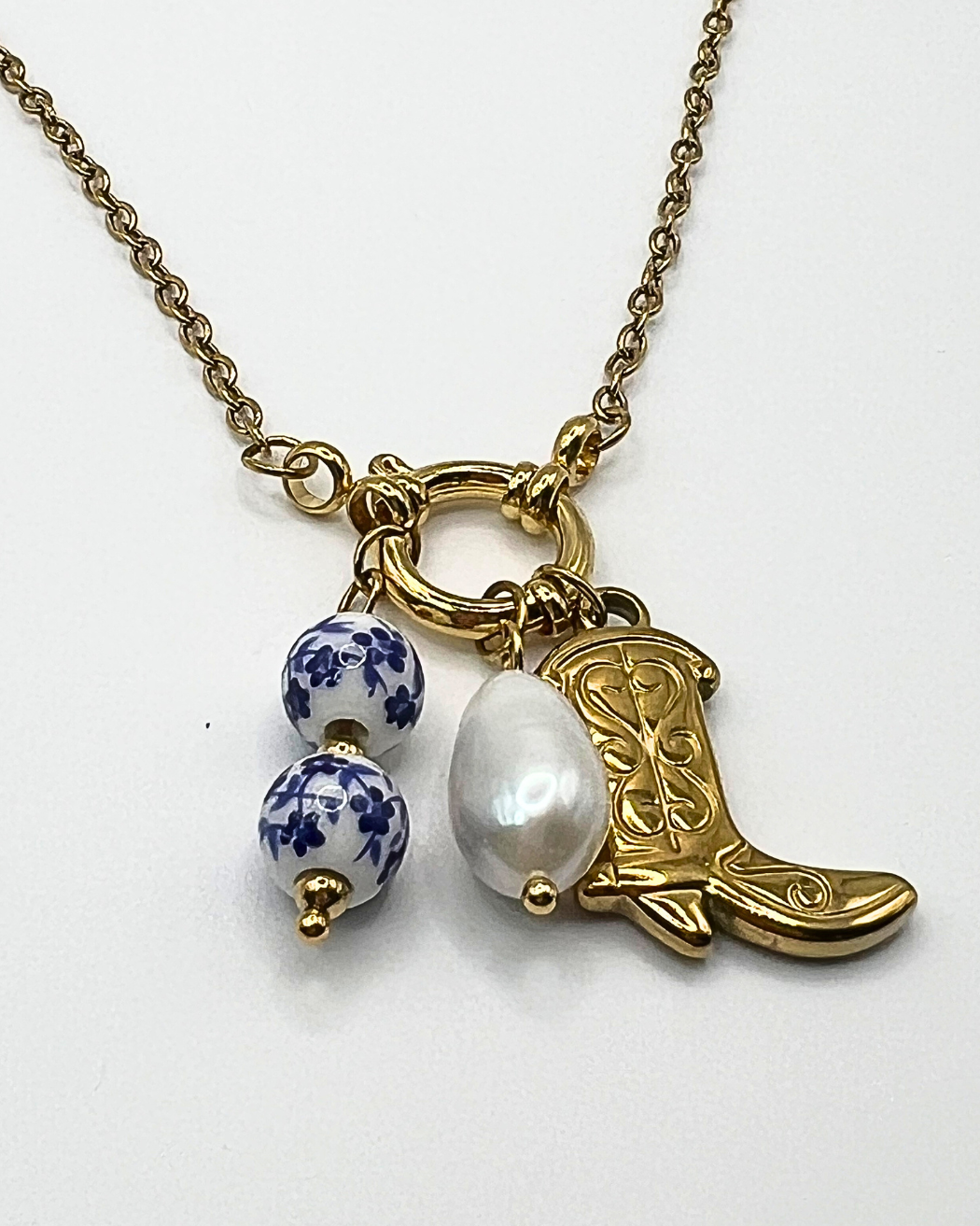Leuke speelse en stoere ketting met bedel trio van delftsblauw, parel en cowgirlaars