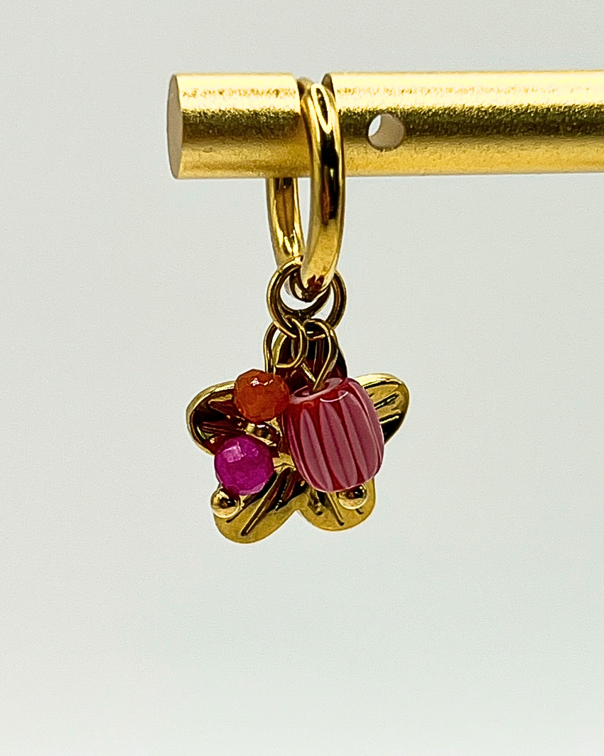 Goudkleurige oorbellen met drie bedels van lila natuursteen en bloem