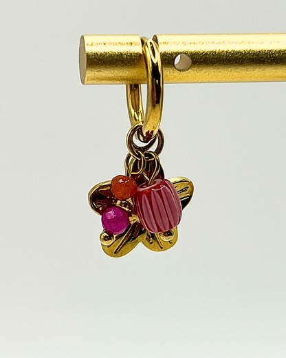 Goudkleurige oorbellen met drie bedels van lila natuursteen en bloem