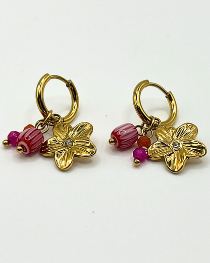 Goudkleurige oorbellen met drie bedels van lila natuursteen en bloem