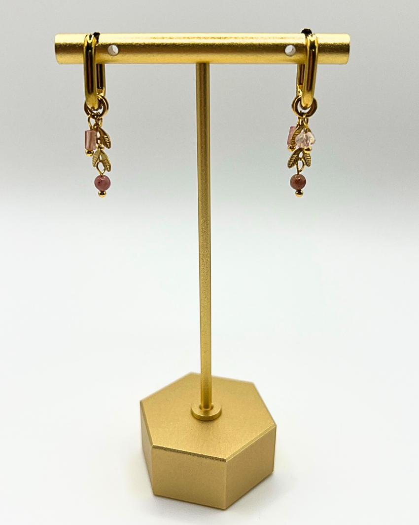 Goudkleurige ovalen oorhangers met schattige bedels in licht roze natuursteen en gouden blaadjes