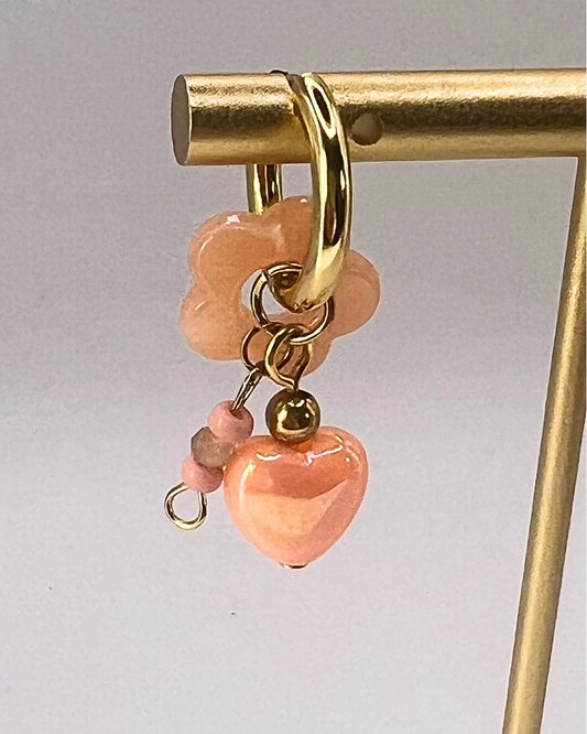 Goudkleurige sweetheart oorringen met zalmkleurige hartjesbedels