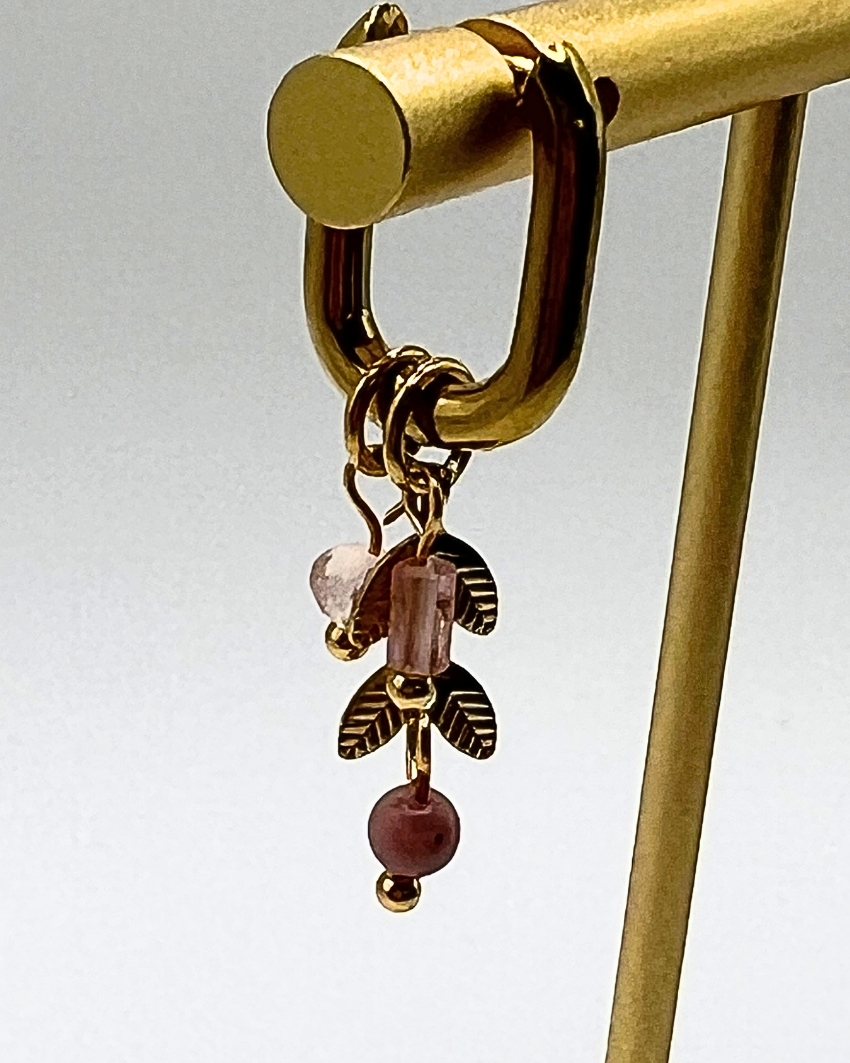 Goudkleurige ovalen oorhangers met schattige bedels in licht roze natuursteen en gouden blaadjes