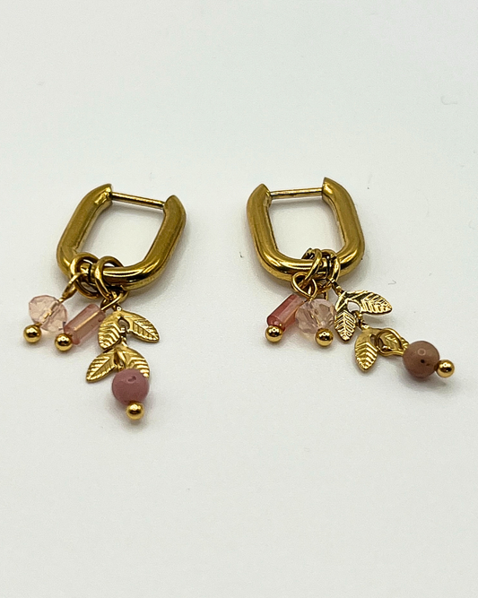 Goudkleurige ovalen oorhangers met schattige bedels in licht roze natuursteen en gouden blaadjes