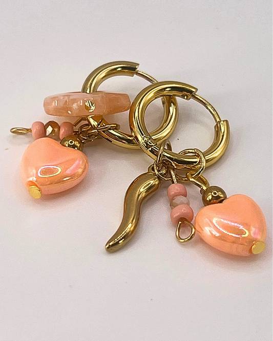 Goudkleurige sweetheart oorringen met zalmkleurige hartjesbedels