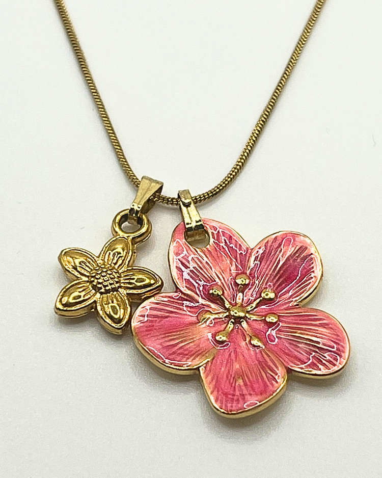 Goudkleurige ketting met bloemenbedels in oudroze en goud