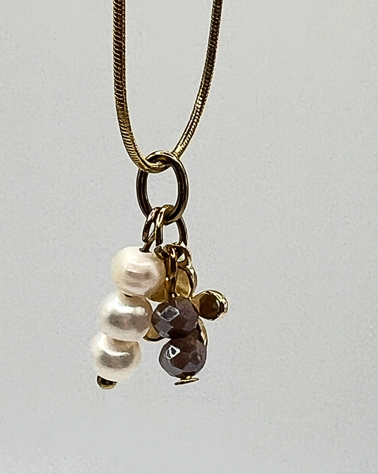 Goudkleurige ketting met drie bedels van parels, bloem en facetkralen