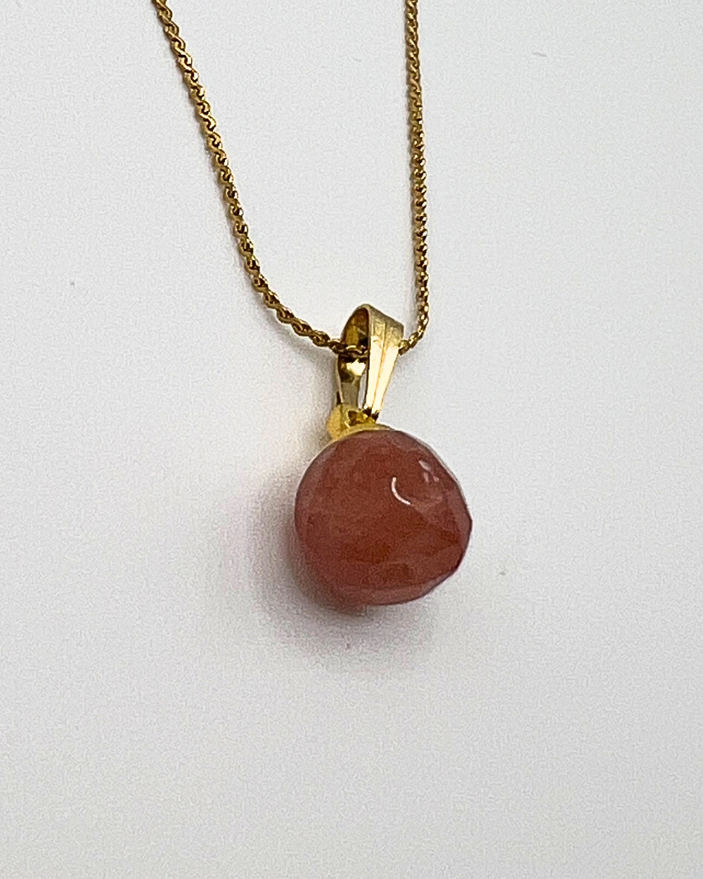 Goudkleurige ketting met aardbei kristal hanger in oud roze kleur