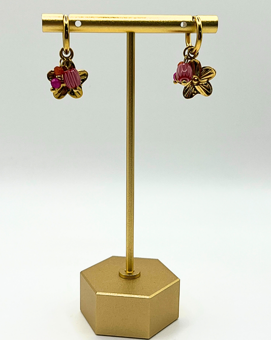 Goudkleurige oorbellen met drie bedels van lila natuursteen en bloem