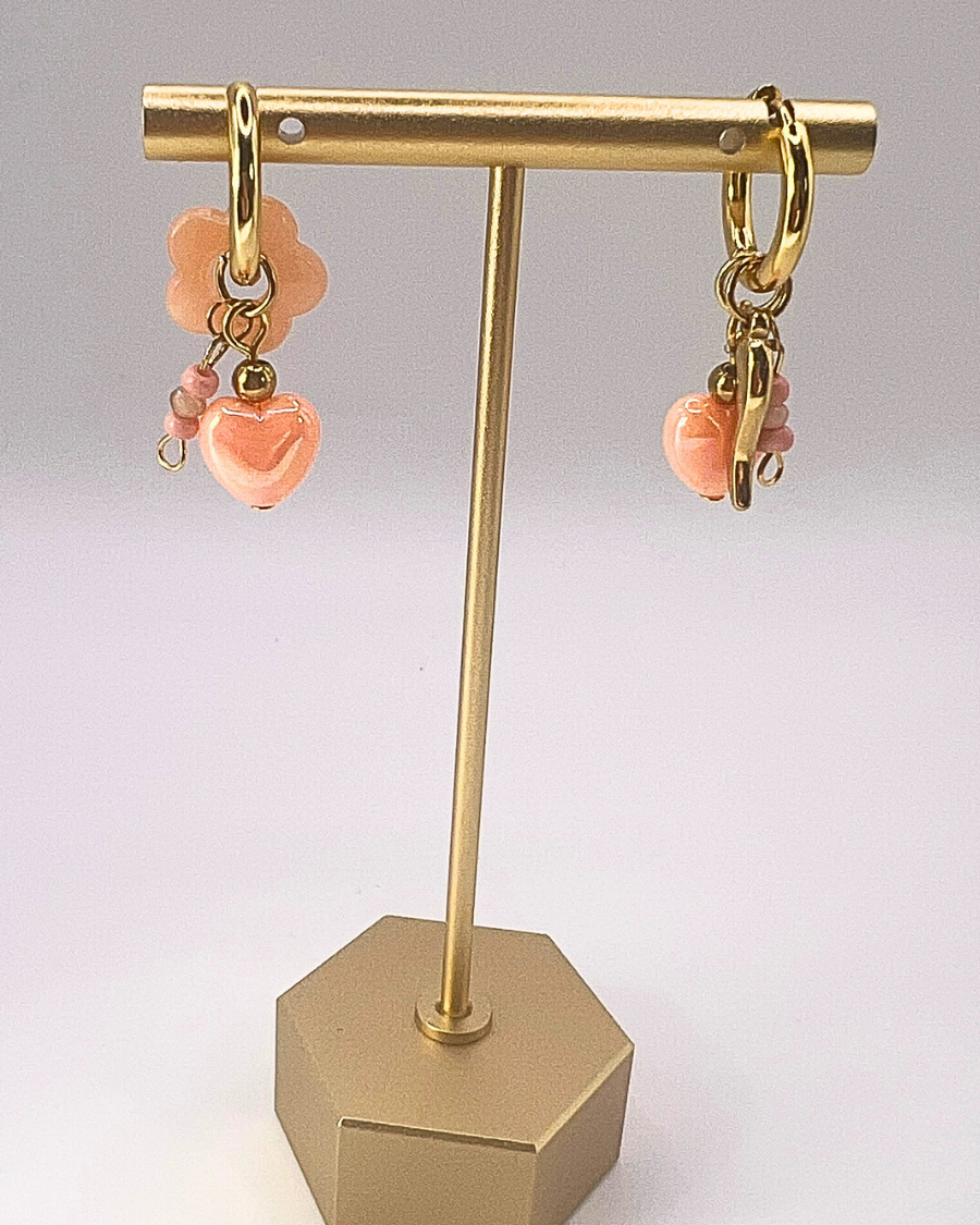 Goudkleurige sweetheart oorringen met zalmkleurige hartjesbedels