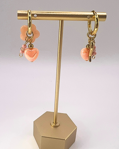 Goudkleurige sweetheart oorringen met zalmkleurige hartjesbedels